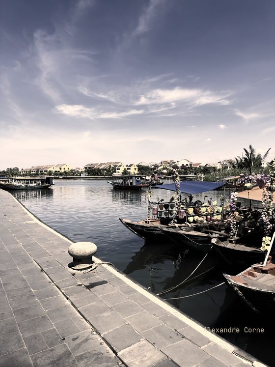 Lifestyle photograph: wooden boats along a river quay